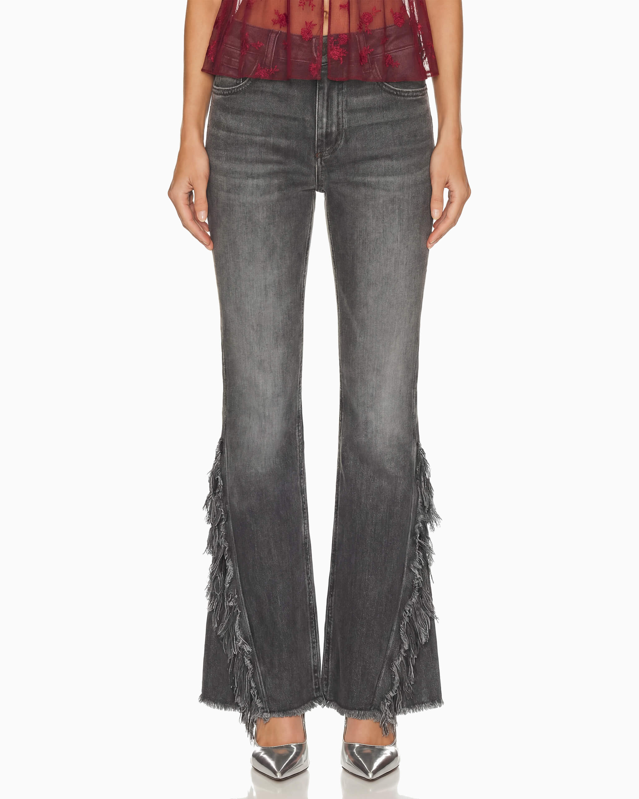Calça Punk flare em jeans cinza lavado vista de frente na modelo, com franjas desfiadas nas laterais das pernas