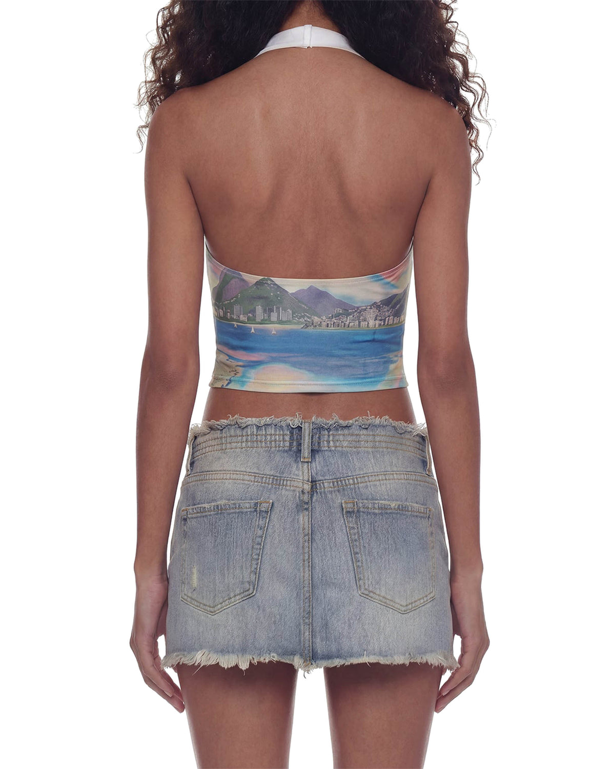 Close de costas da Blusa Brasilidades na modelo, costas nuas com amarração no pescoço e estampa de mar e montanhas