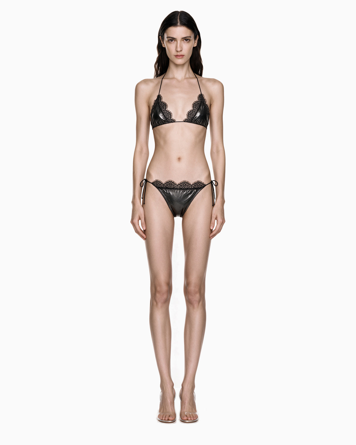 Modelo vestindo Biquíni Metalizado Com Renda preto, com top triângulo e calcinha de amarrar nas laterais, vista frontal de corpo inteiro