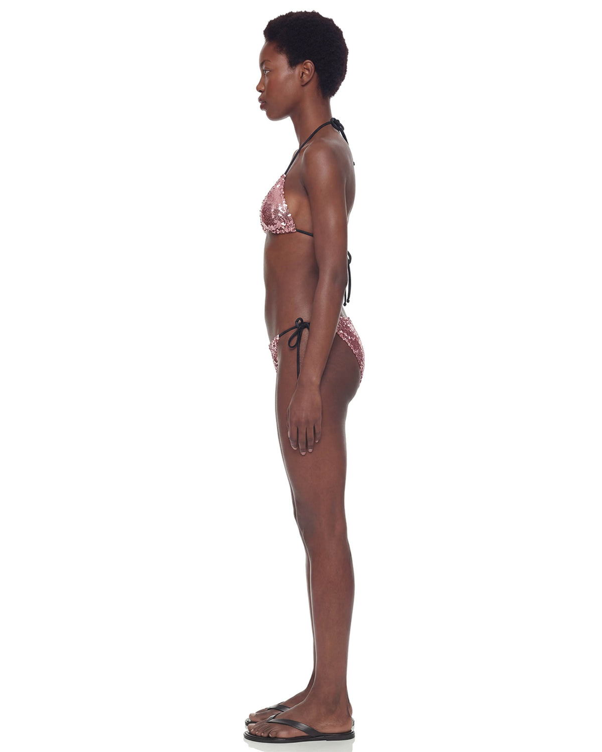 Vista de perfil do Biquíni Triângulo Paetê Aura rosa na modelo, mostrando o caimento lateral