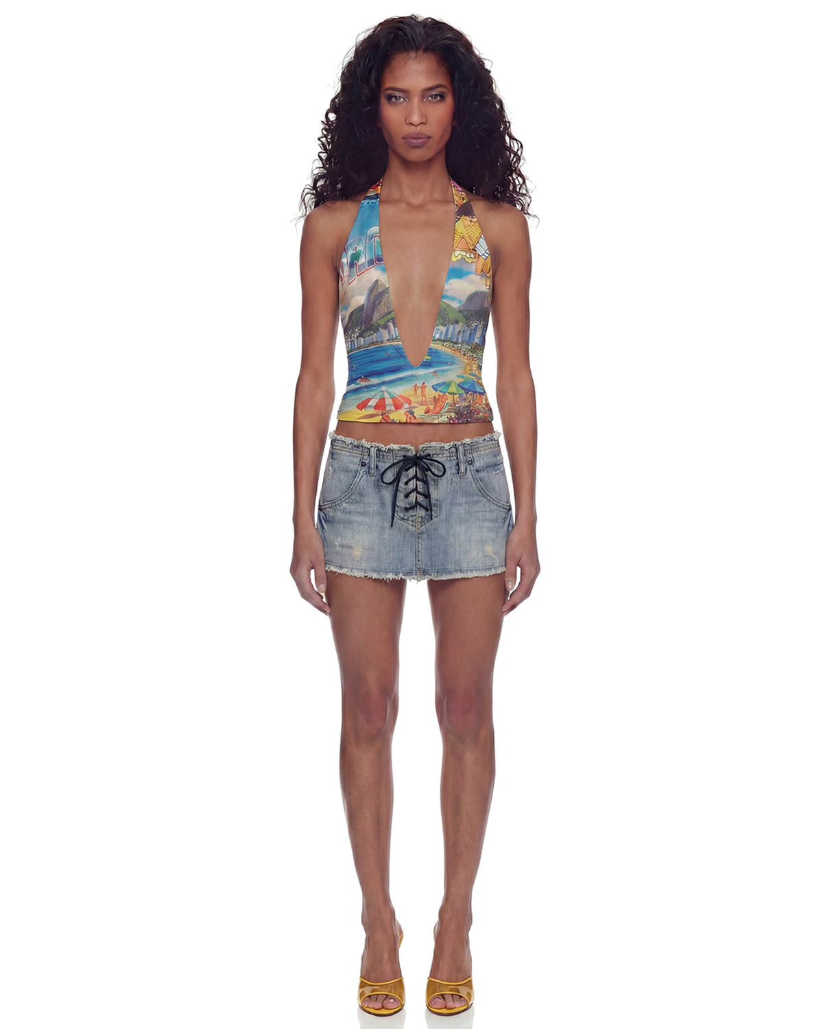 Modelo de corpo inteiro usando a Blusa Brasilidades cropped estampada com decote V profundo, alças frente-única e saia jeans