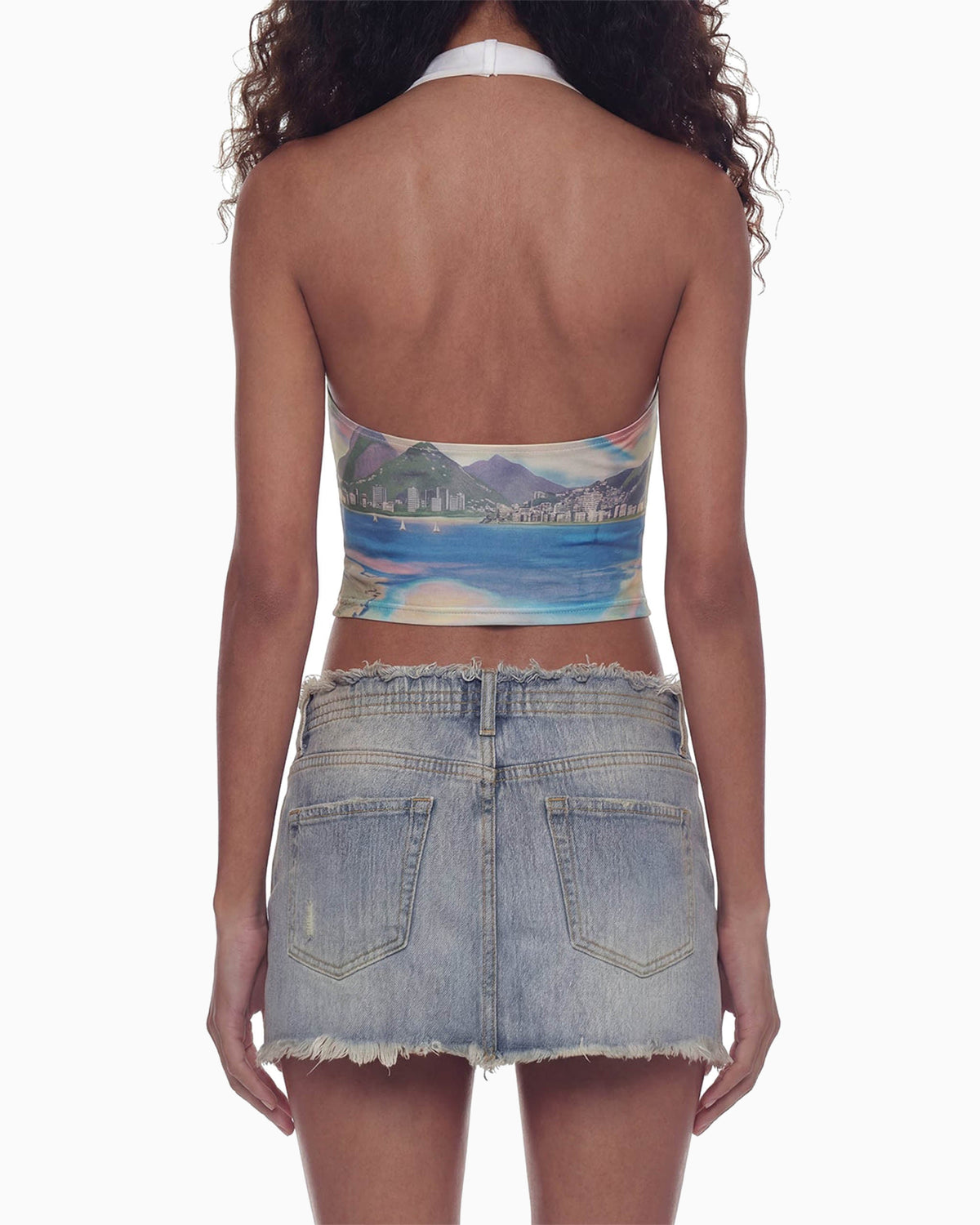 Close de costas da Blusa Brasilidades na modelo, costas nuas com amarração no pescoço e estampa de mar e montanhas