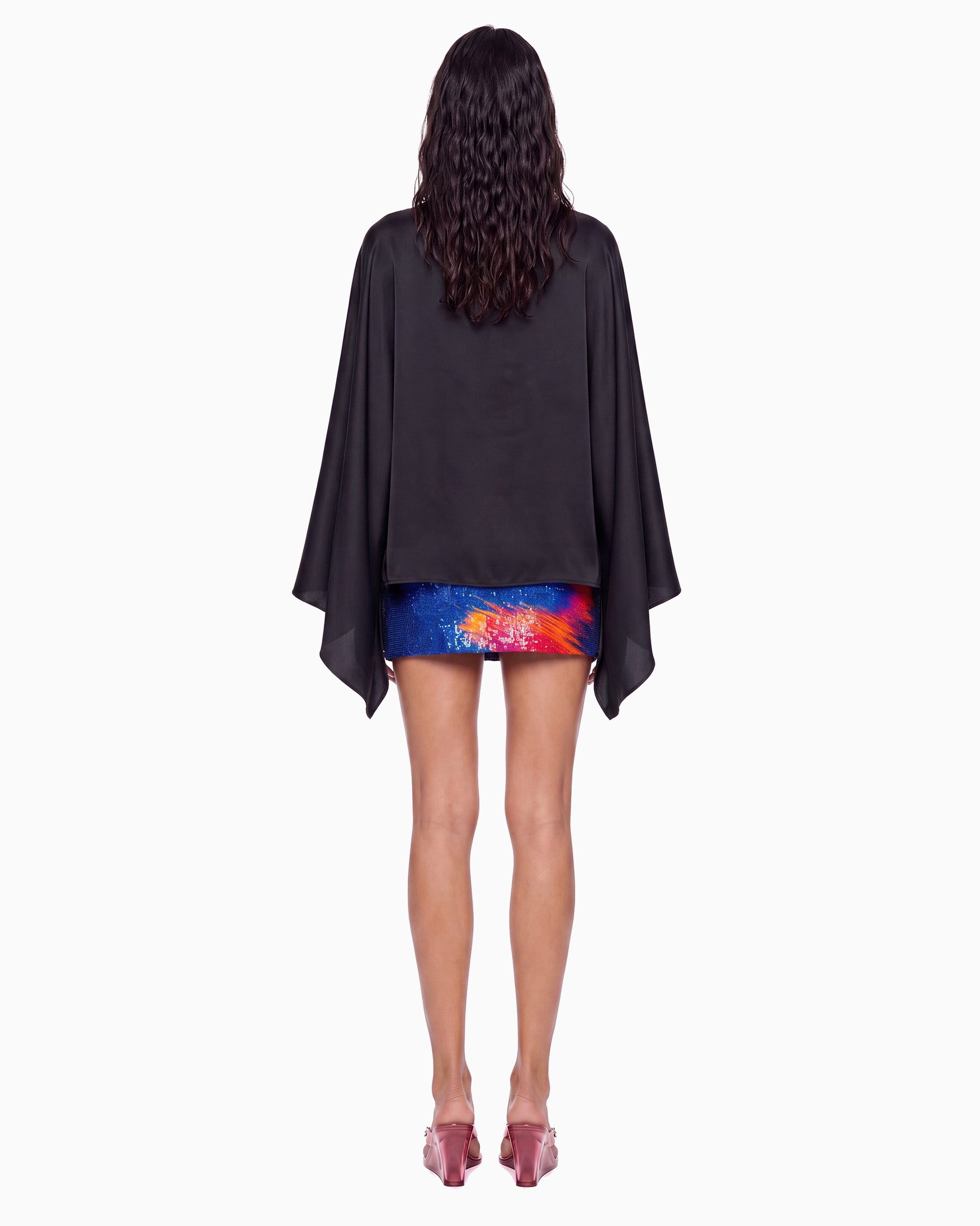 Vista de costas da Blusa Manga Morcego Crepe Ivo preta na modelo, corpo solto e pontas das mangas caídas