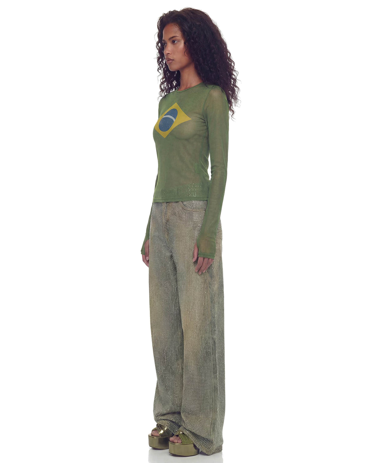 Modelo de perfil com Blusa Tule Bandeira verde de manga longa, caimento justo e estampa da bandeira do Brasil