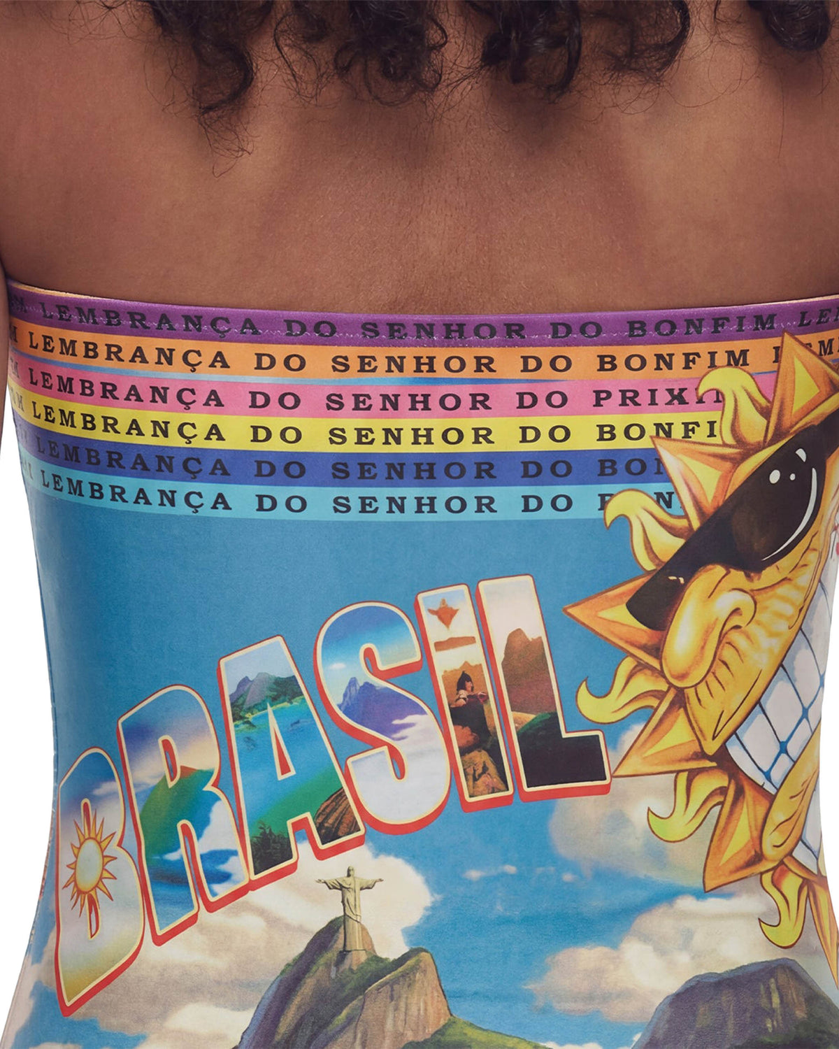 Detalhe da estampa do Body Brasilidades com letras BRASIL, Cristo Redentor e sol sorridente de óculos