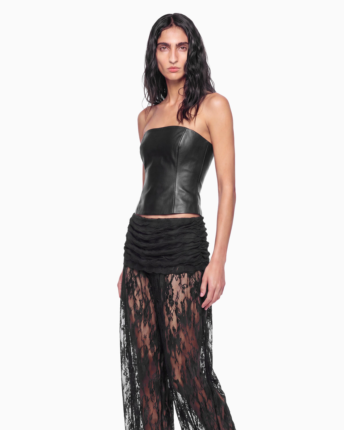 Close da pala drapeada da Calça Aladim Haze preta na modelo, cintura baixa franzida e renda floral transparente
