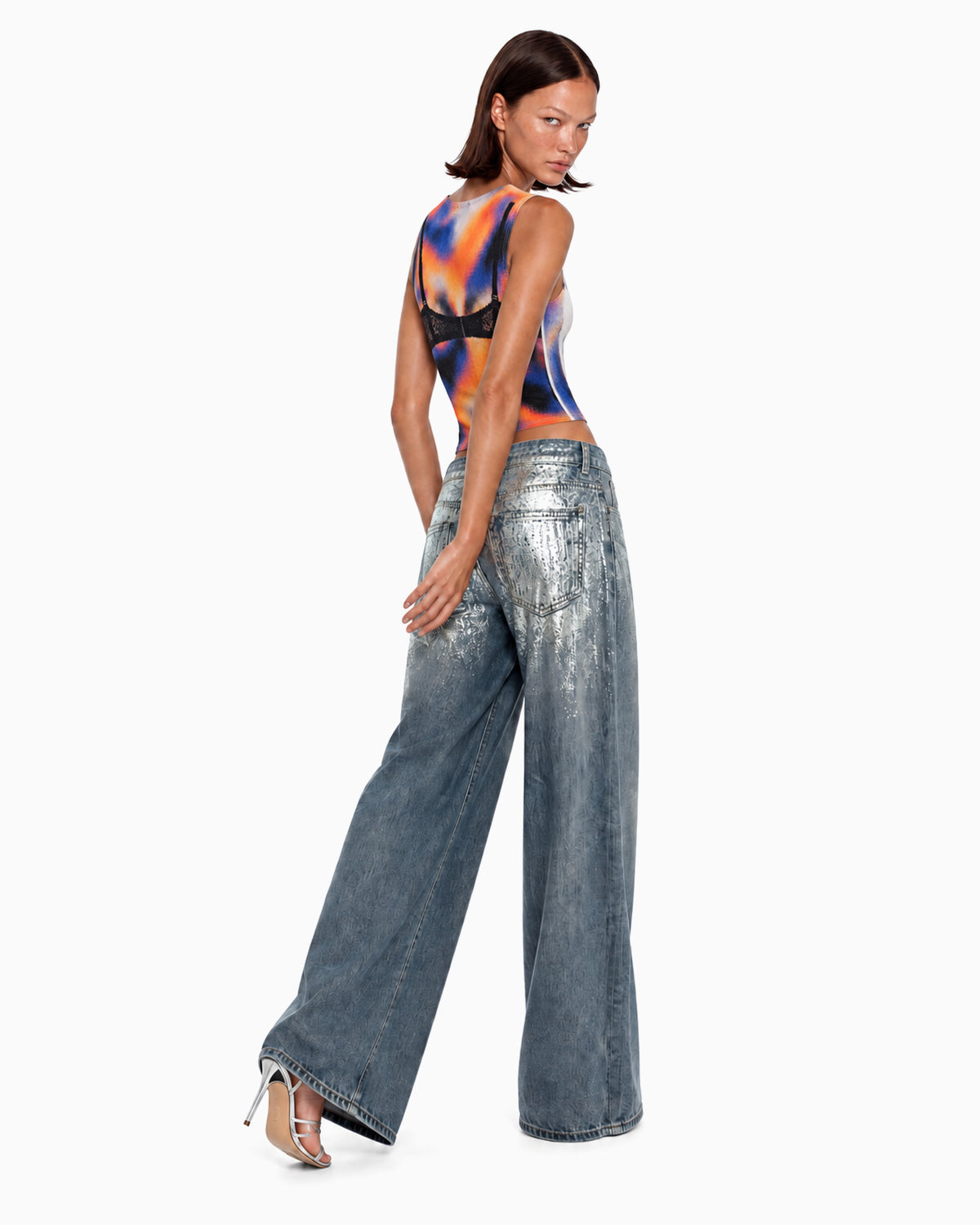 Costas da Calça Jeans Wide Foil Prata na modelo, com acabamento metalizado