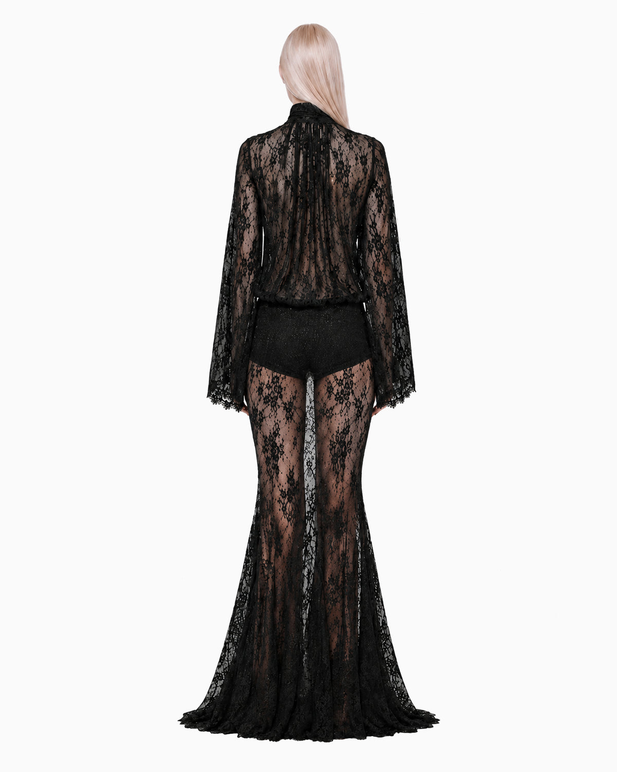 Costas do look Renda Haze preto na modelo, blusa de manga flare e saia longa sereia em renda transparente