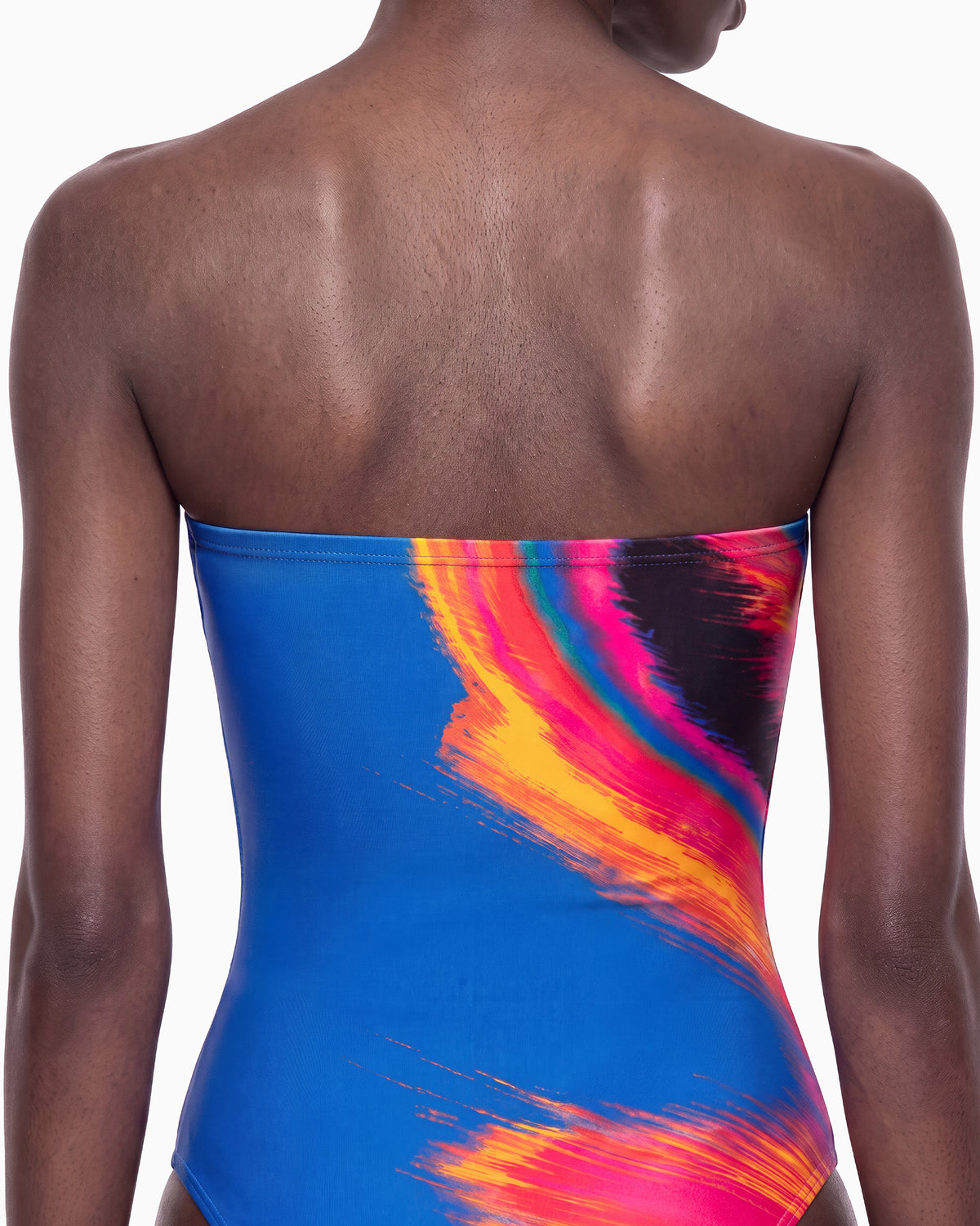 Detalhe das costas do Maiô Surf azul, com pinceladas laranja e pink cruzando a parte de trás