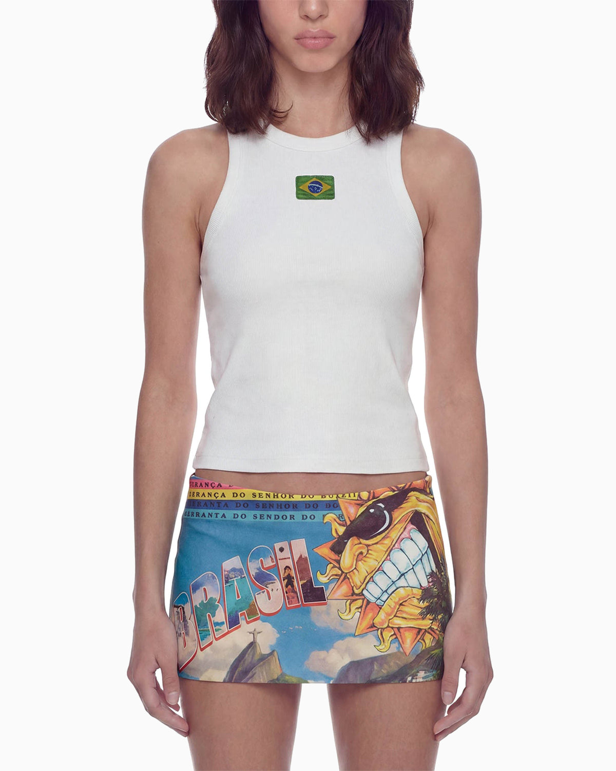 Detalhe frontal da Mini Saia Brasilidades na cintura, com estampa colorida, sol sorridente e letreiro BRASIL