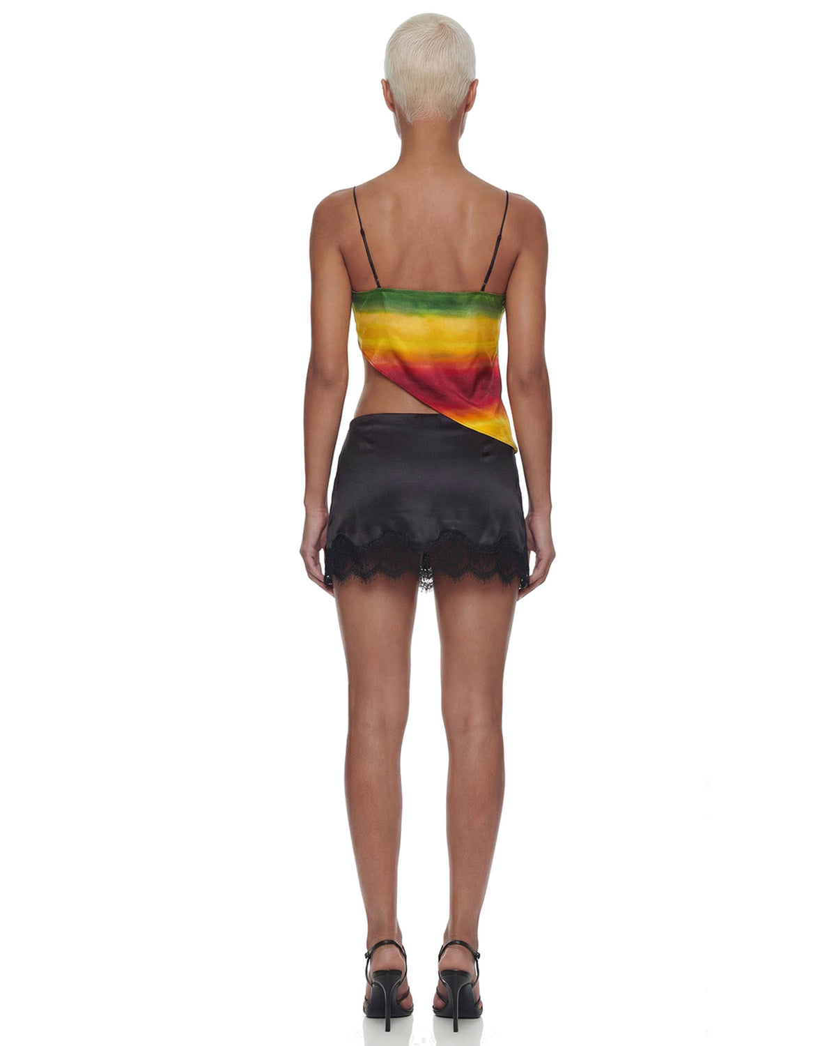Costas da Mini Saia Cetim Renda Caipirinha preta acetinada com barra de renda, comprimento curtíssimo na modelo