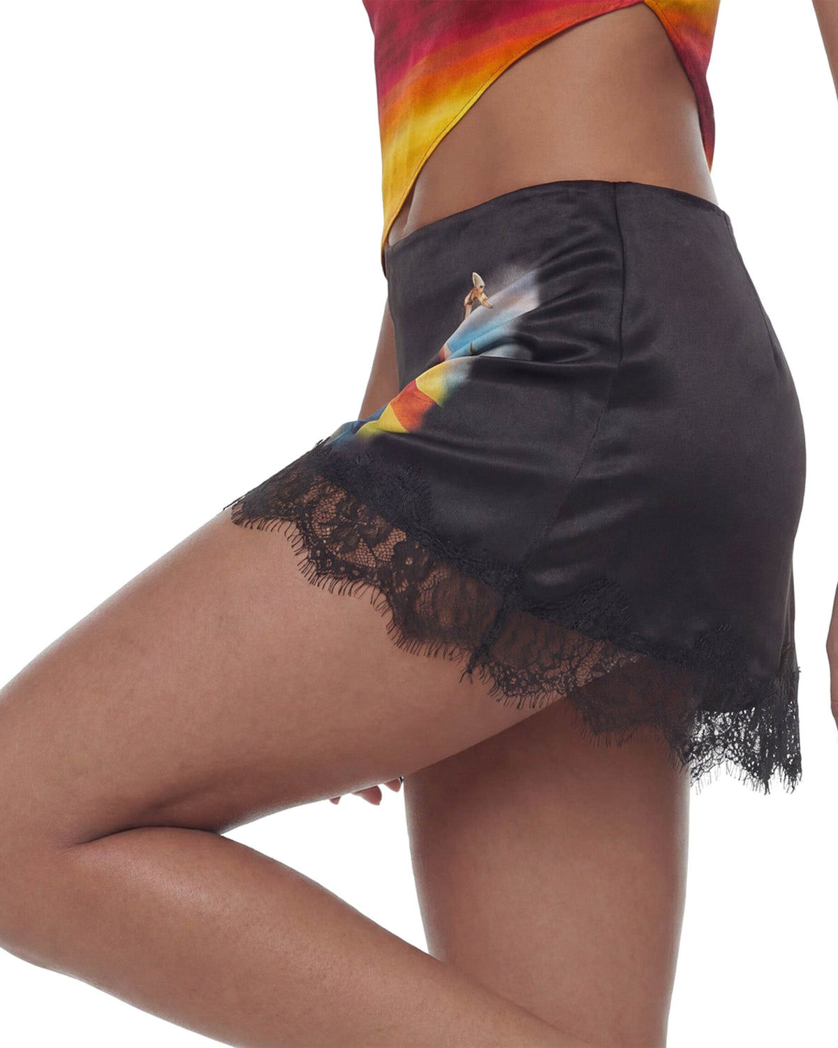 Detalhe da barra de renda preta e do cetim da Mini Saia Cetim Renda Caipirinha na cintura da modelo