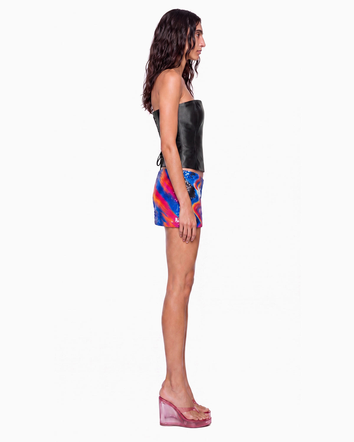 Vista lateral da Mini Saia Paetê Surf azul de paetês com corset preto, mostrando o brilho dos paetês no quadril