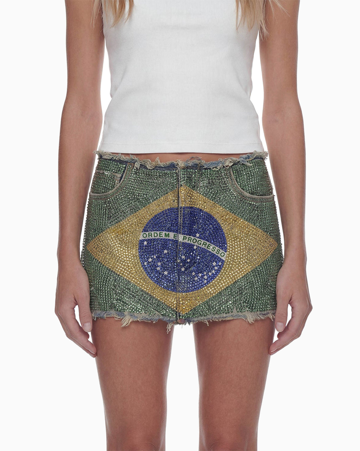 Close frontal da Mini Saia Strass Bandeira mostrando a bandeira do Brasil em strass sobre jeans verde