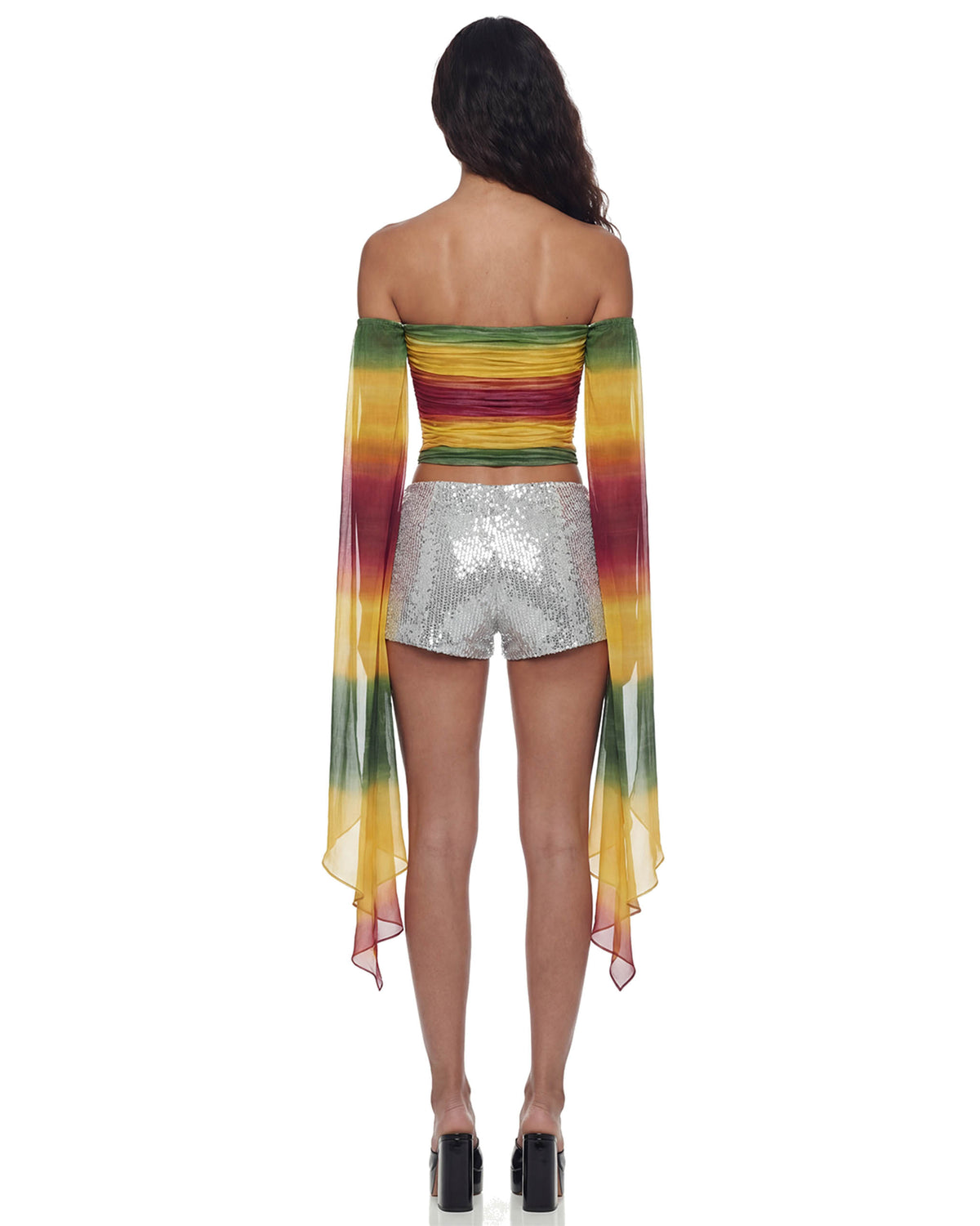 Vista de costas do Mini Shorts Paetê Aura prata na modelo, todo em paetês com caimento curto