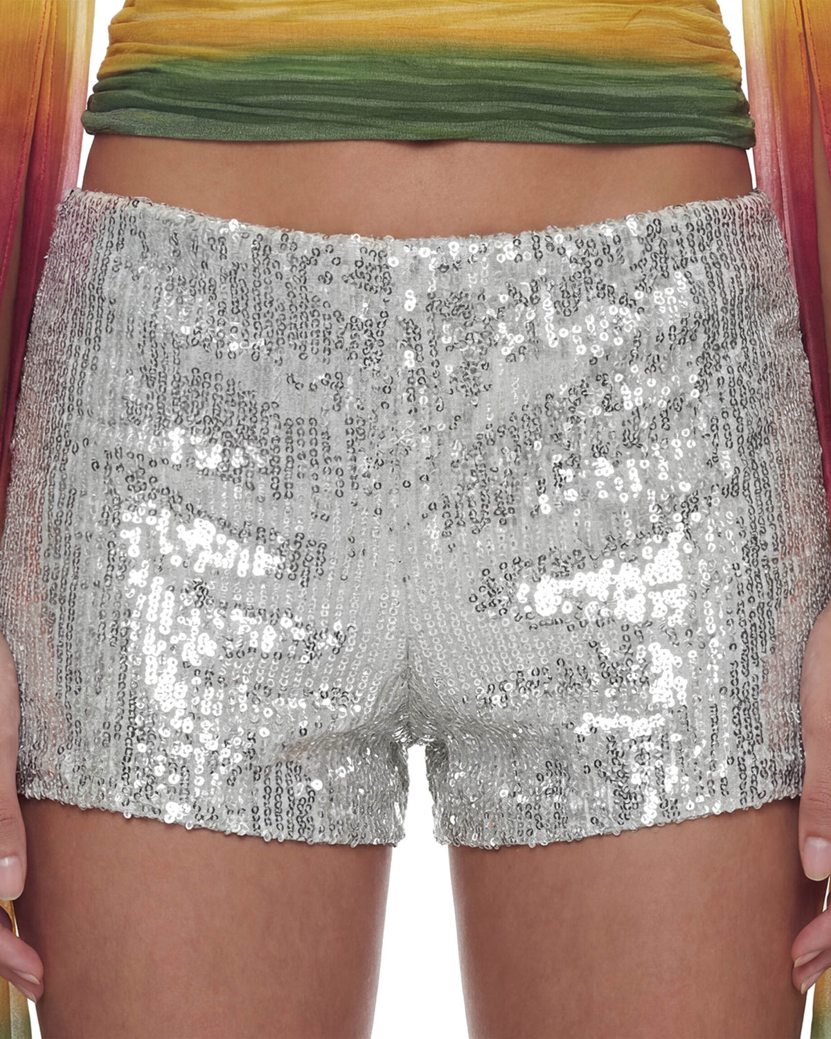 Detalhe frontal do Mini Shorts Paetê Aura prata na modelo, cintura baixa coberta de paetês brilhantes