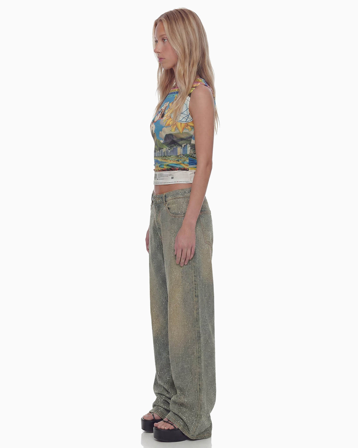 Perfil da modelo com regata Brasilidades cropped estampada, caimento justo ao corpo