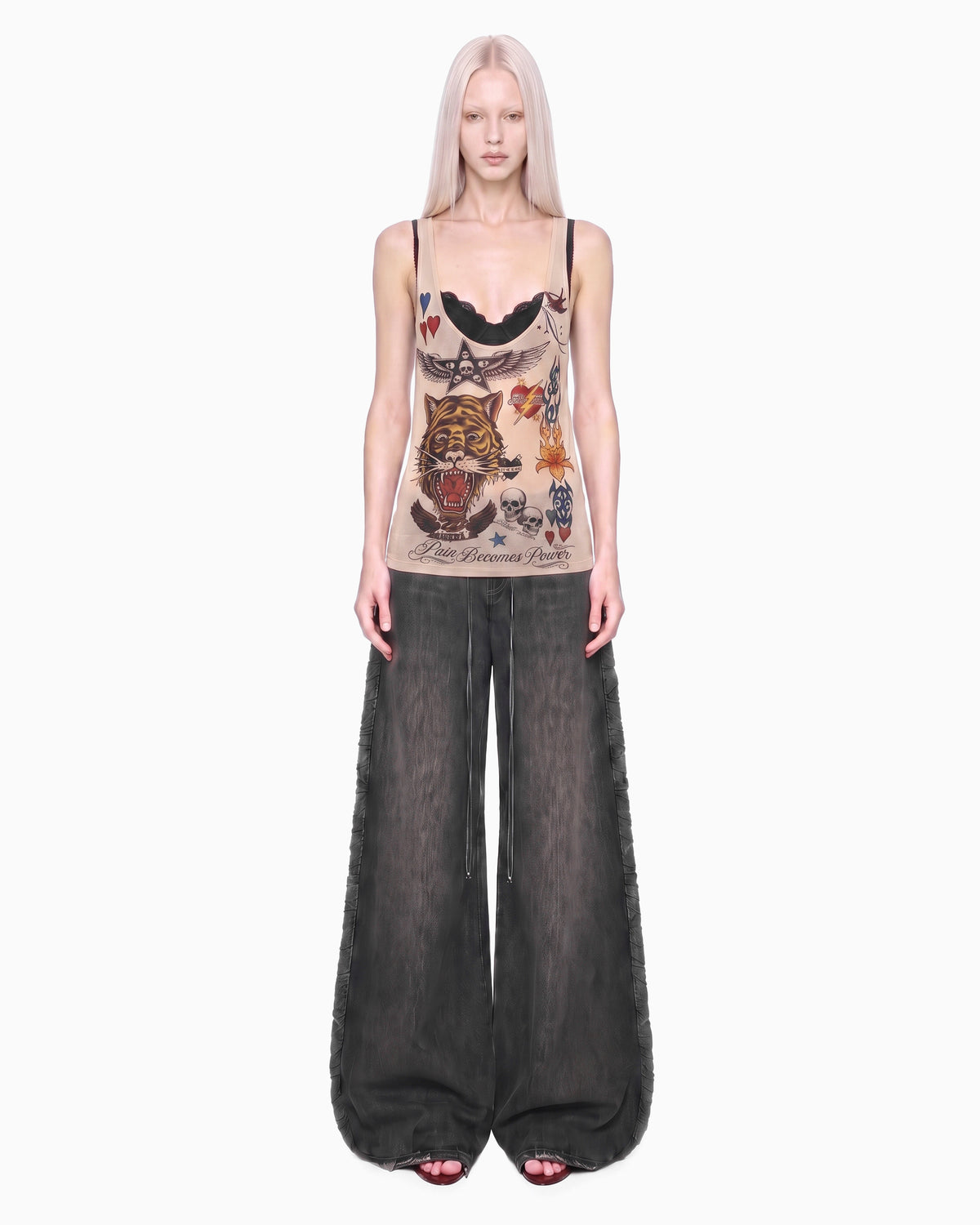 Regata Cavada Tule Tigre bege na modelo de corpo inteiro, braços soltos e calça jeans larga cinza escuro