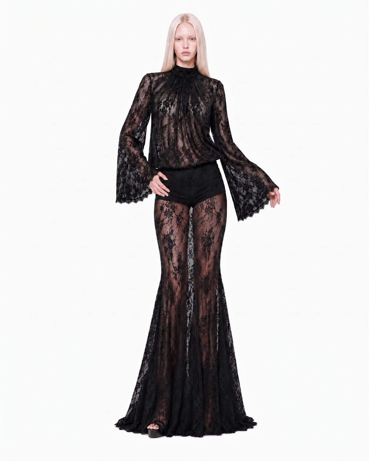 Modelo de frente com a Saia Longa Renda Haze preta transparente e blusa de renda de manga sino