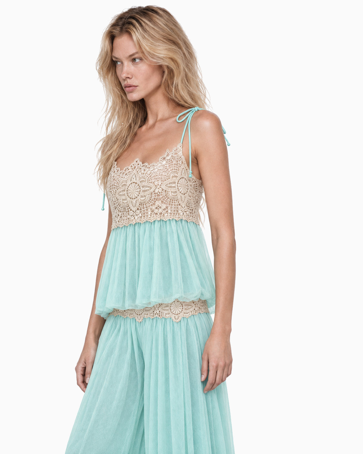 Modelo vestindo Top Tule Renda Alça Amarração acqua com busto em renda bege, combinado com Calça Tule Aladim Renda Bege, vista lateral
