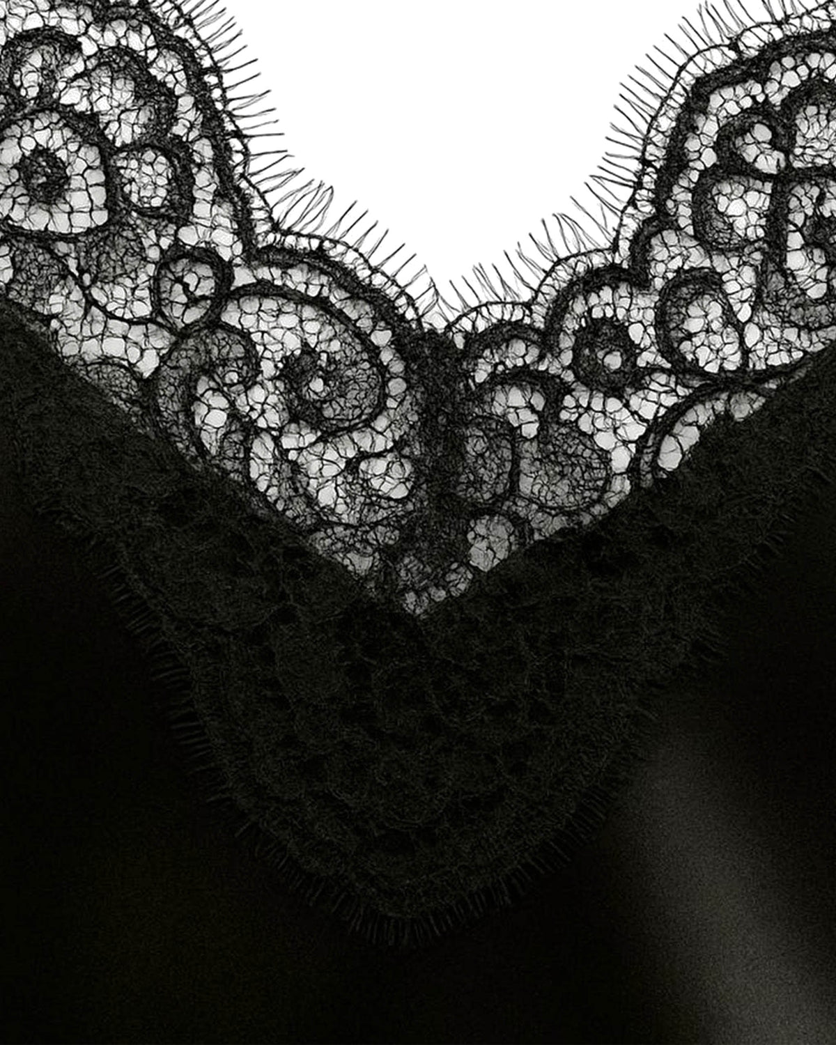 Detalhe do decote V em renda floral do Vestido Affair preto acetinado