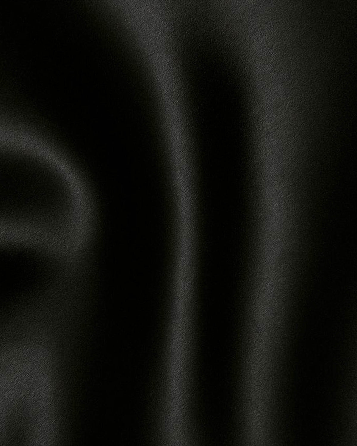 Detalhe do tecido acetinado preto do Vestido Affair com brilho suave e caimento fluido