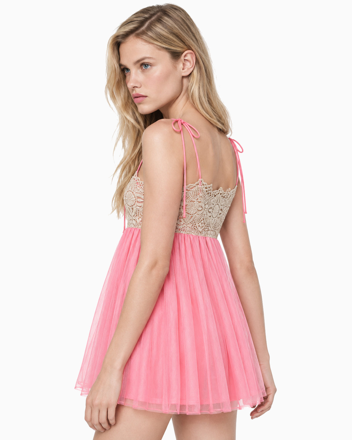 Modelo vestindo Vestido Curto Tule Renda Bege rosa, vista lateral com costas abertas e saia de tule