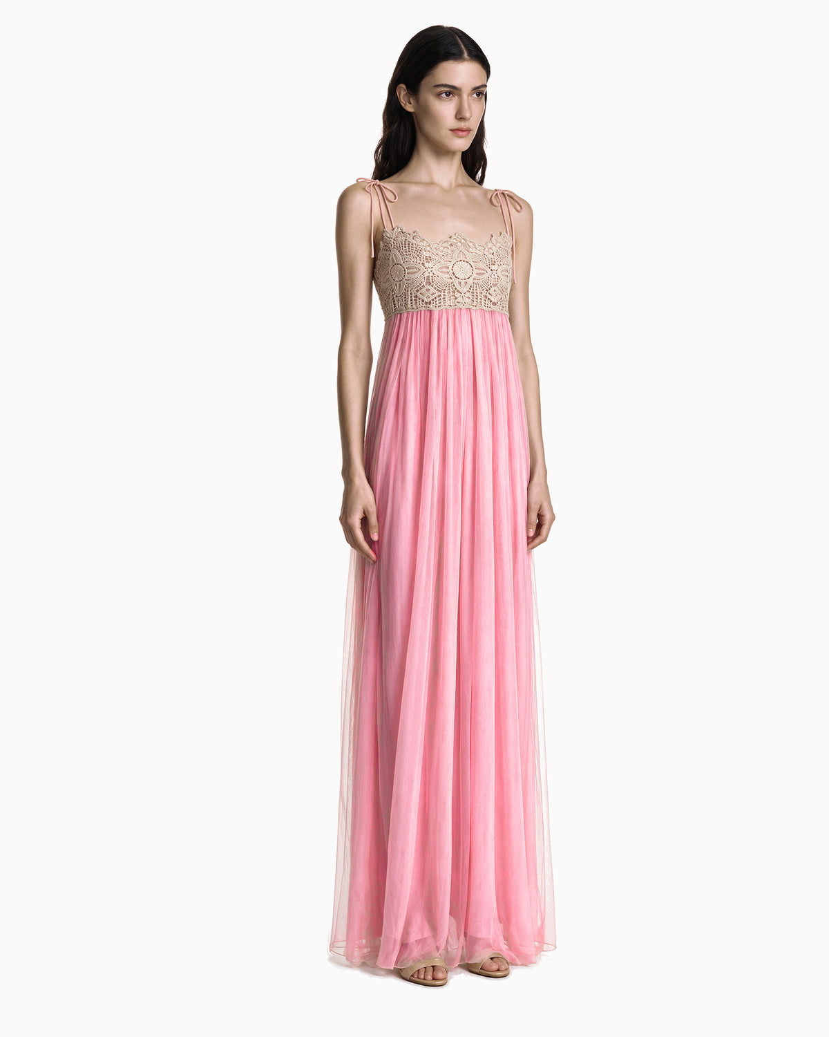 Modelo vestindo Vestido Longo Tule Com Renda rosa, com busto bege rendado e alças de amarração, vista de corpo inteiro em três quartos