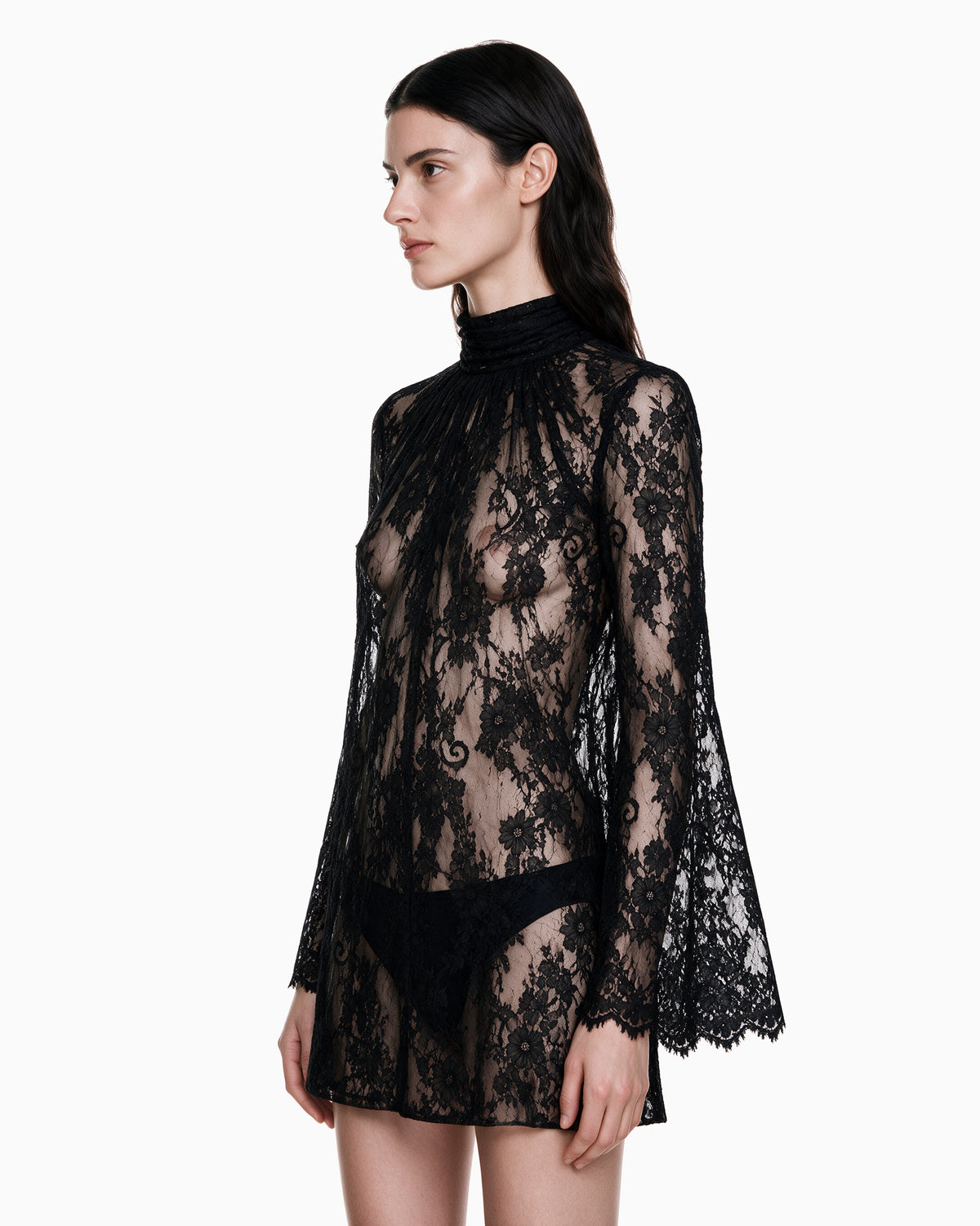 Modelo vestindo Vestido Manga Flare Gola Renda Haze preto, vista lateral das mangas flare com barra de renda