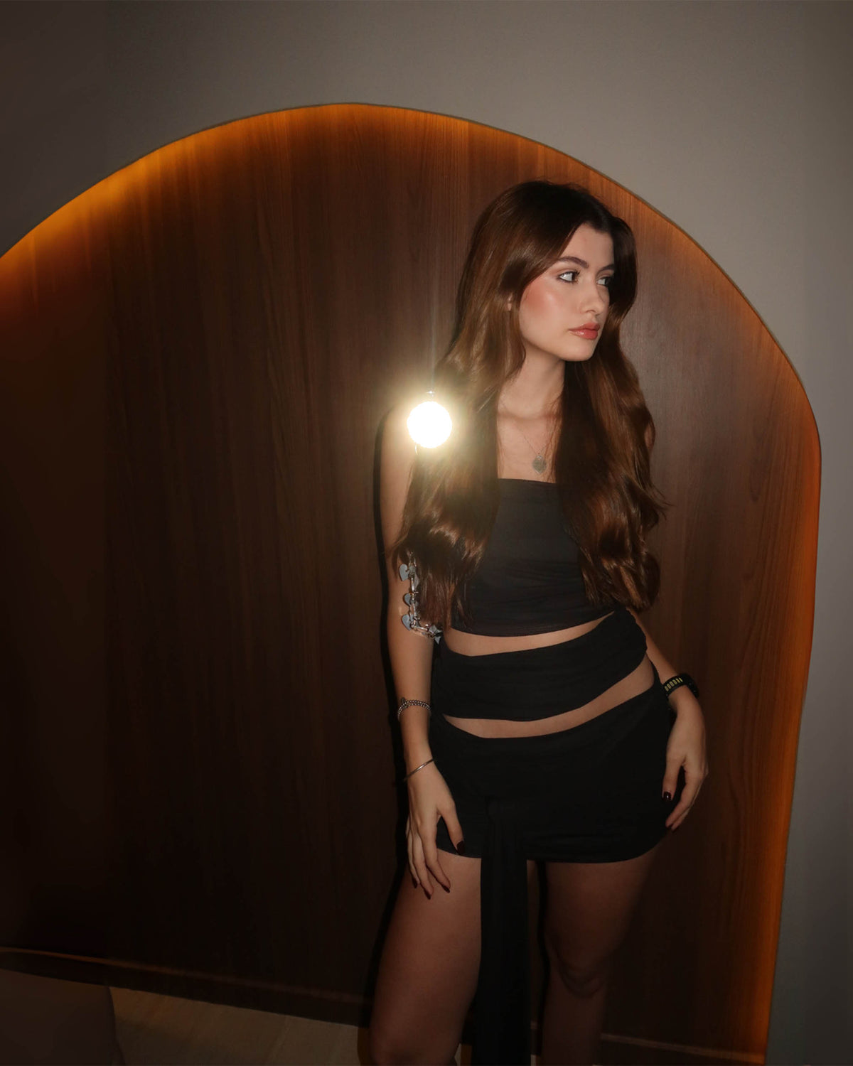 Modelo de tres-quartos com Vestido Siena preto curto, recorte na cintura e caimento leve em tule