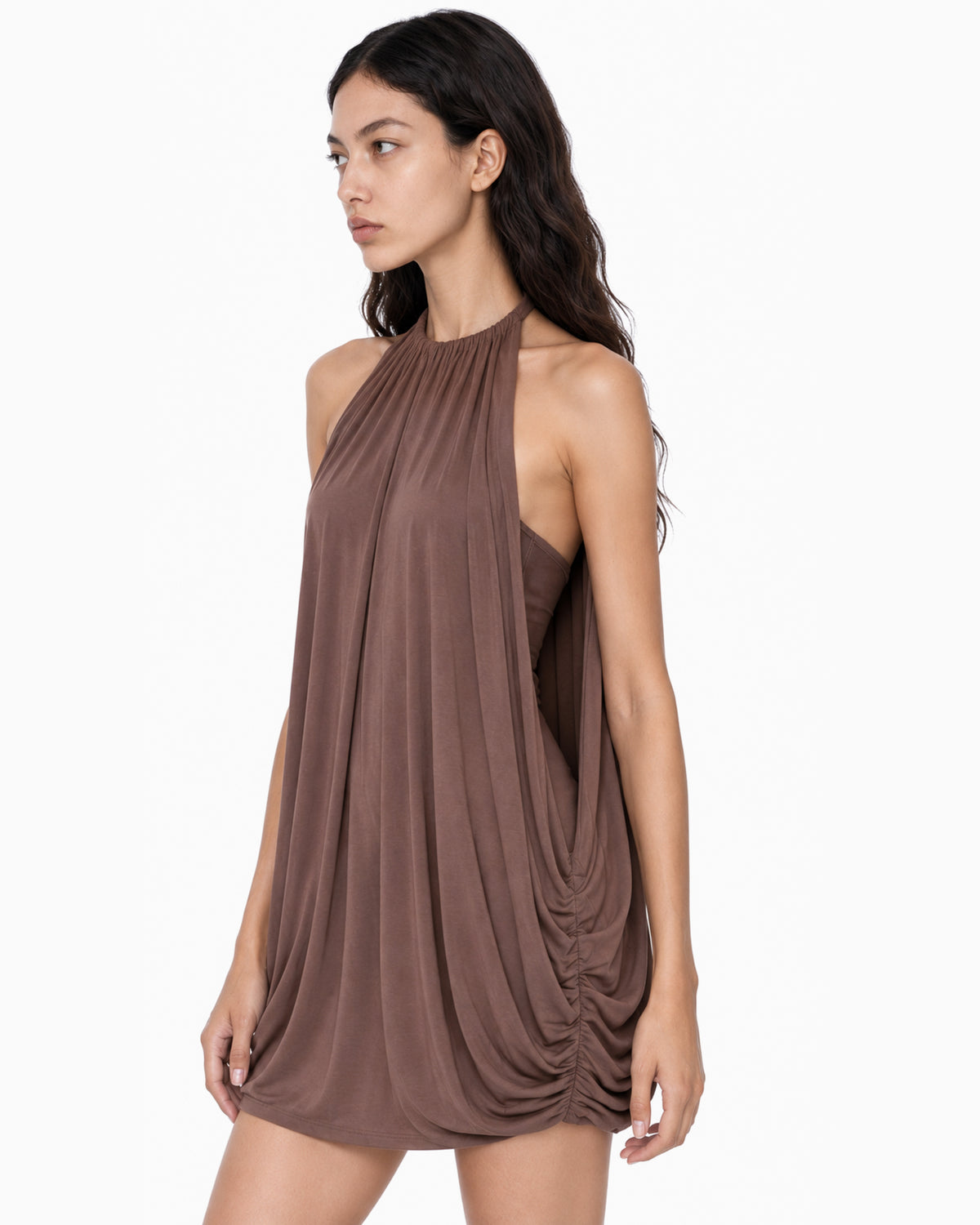 Modelo vestindo Vestido Solto Drapeado Mistral marrom, gola alta franzida e drapeado nas laterais, vista lateral